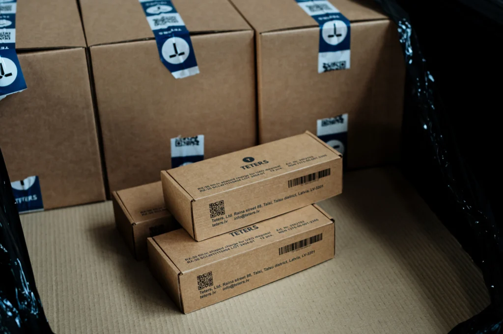 Stacked cardboard boxes and smaller labeled parcels arranged for organized product assembly and secure shipment.