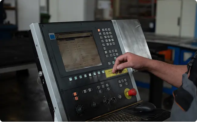 Machine operator using CNC interface for metal fabrication operations
