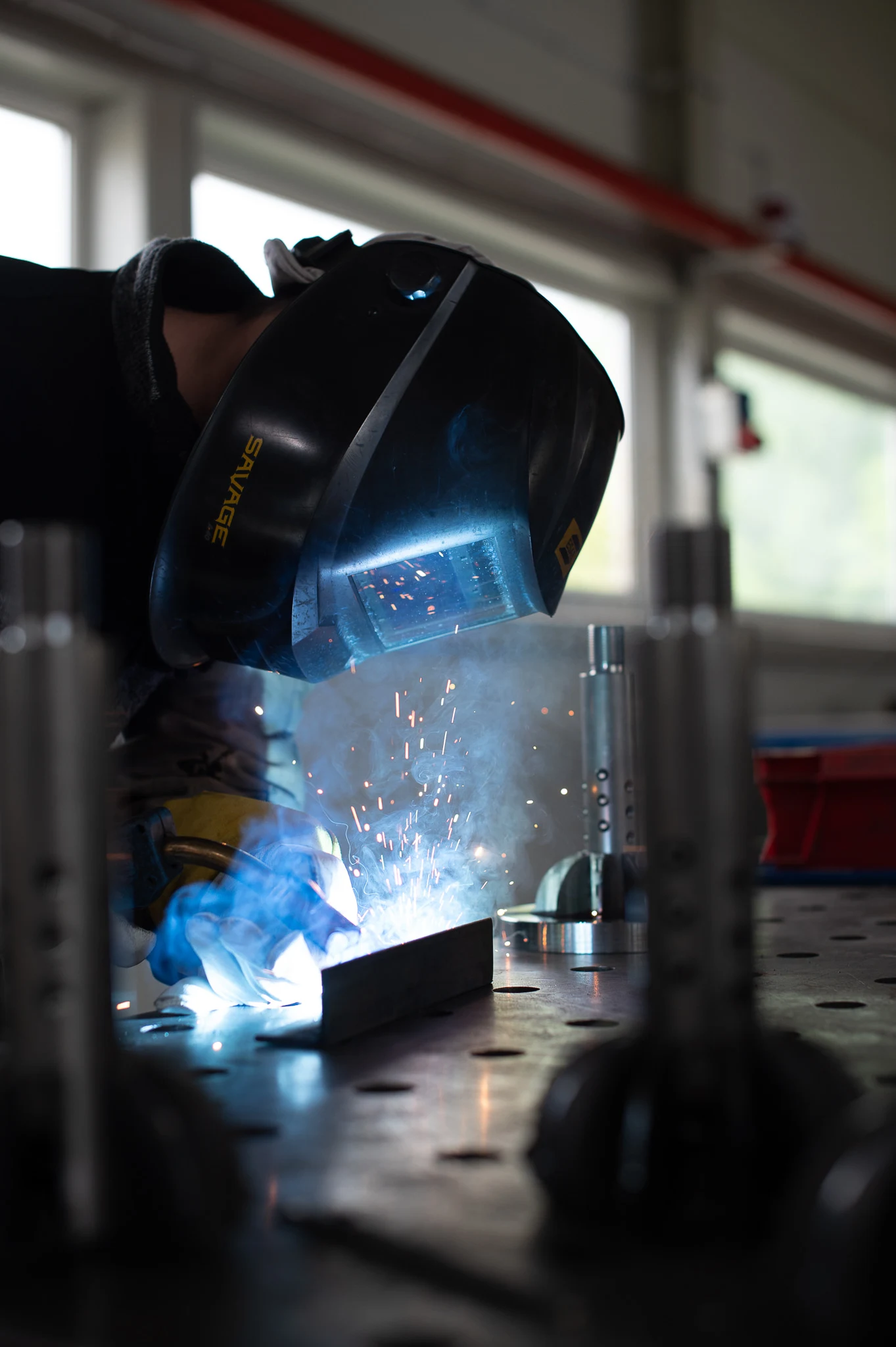 Skilled technician performing expert metal joining with protective gear during precision welding operations.