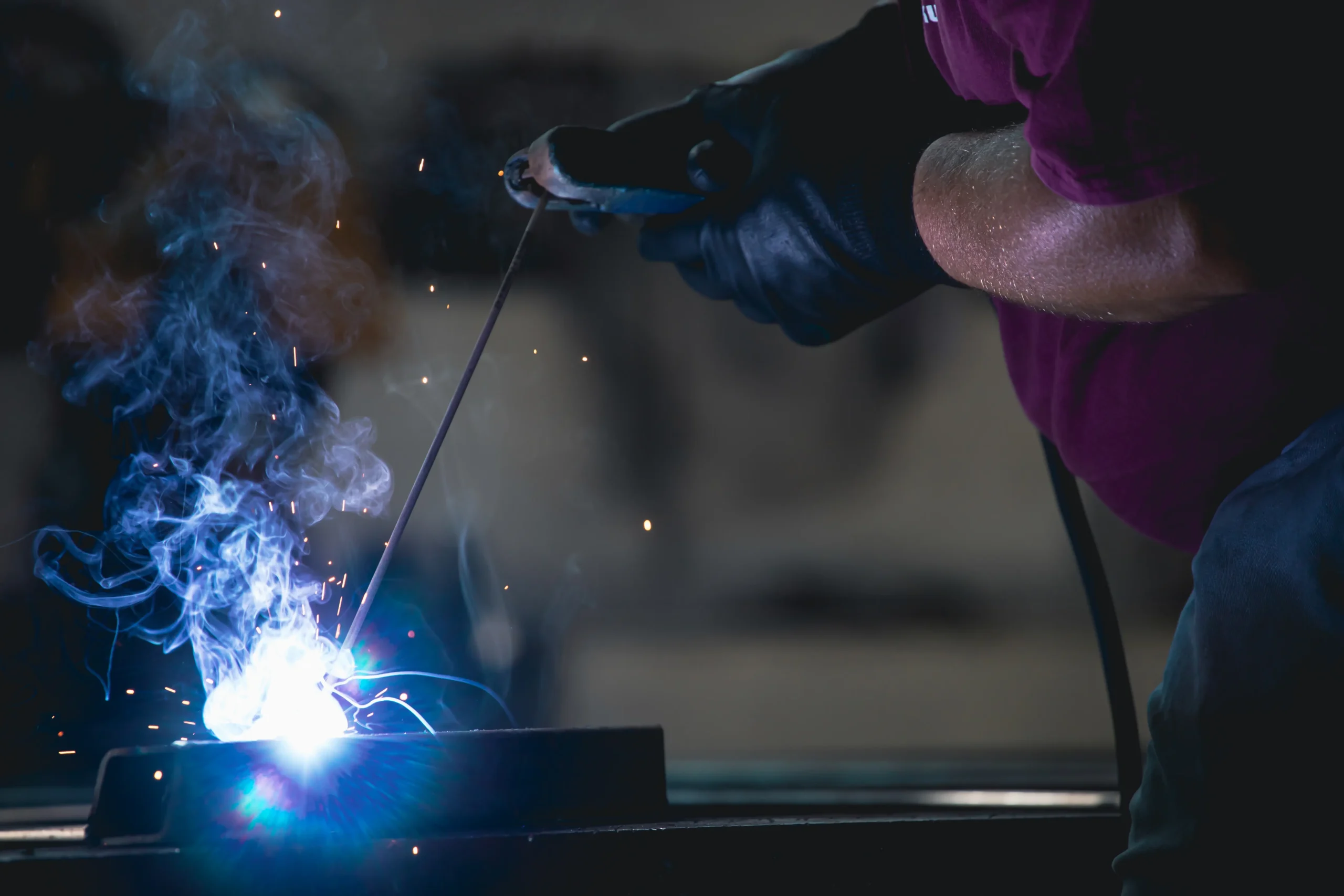 Certified welder executing high-quality arc welding with precision and safety gear.
